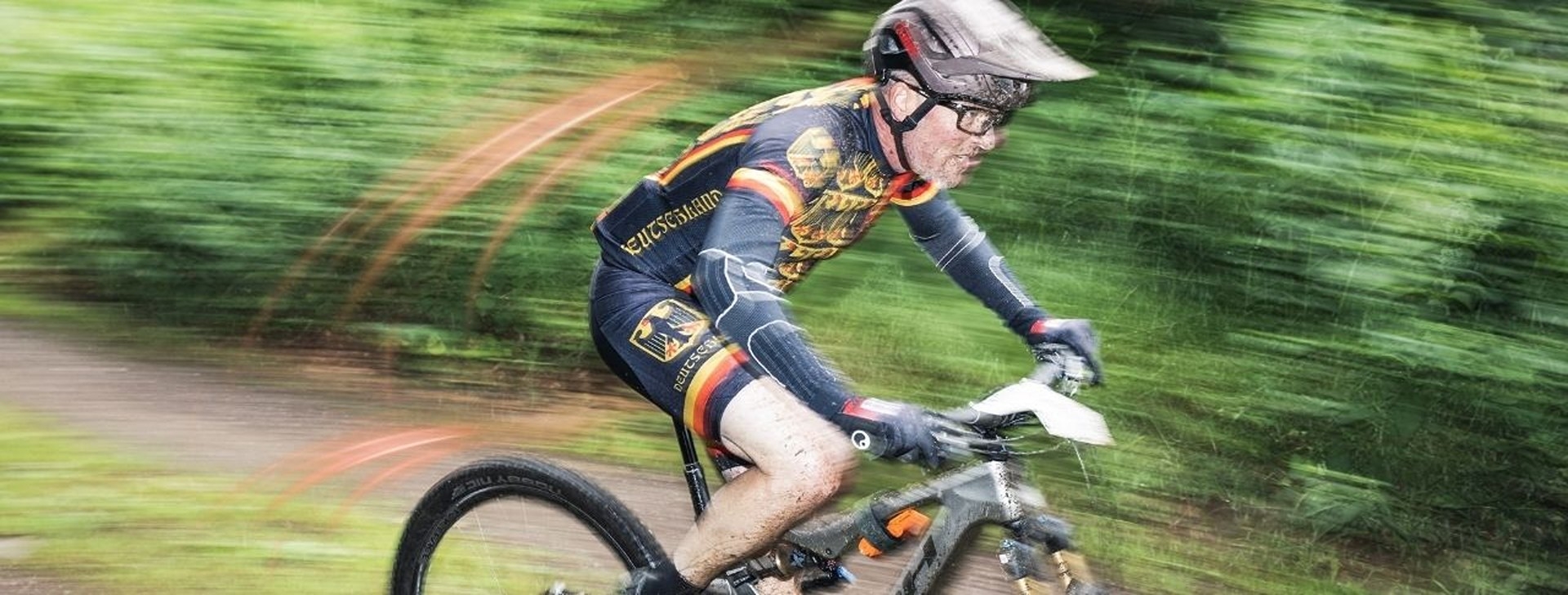 Das Bild zeigt einen E-Bike-Fahrer, der dynamisch einen Waldweg in St. Wendel befahren wird.