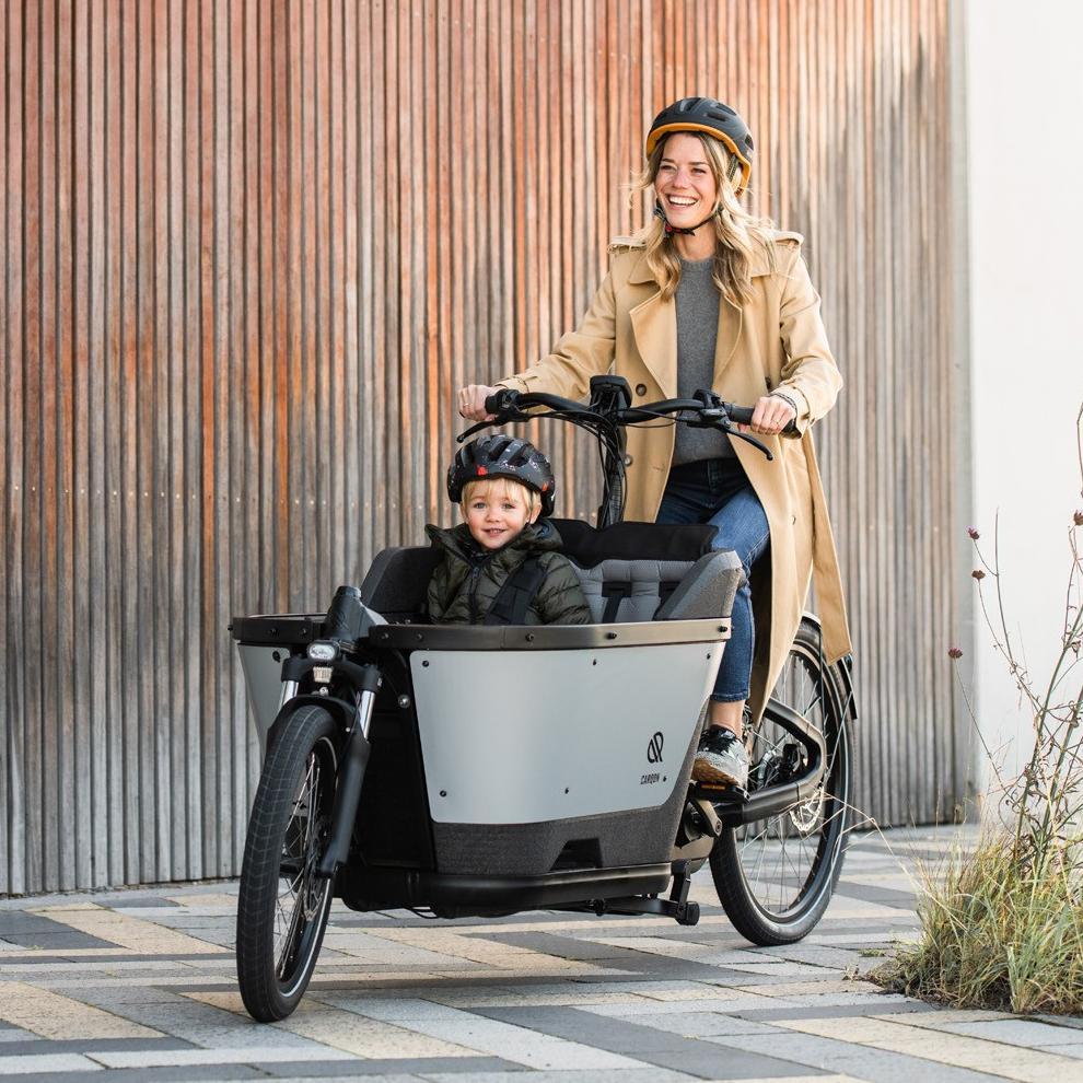 Frau mit Kind in Transportbox sitzt auf dem Carqon Cruise