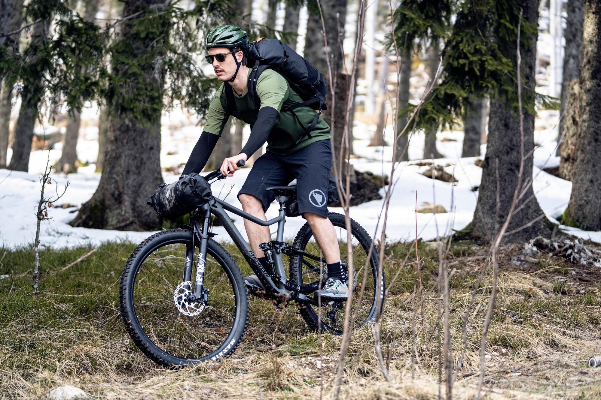 Ein Radfahrer genießt eine Offroad-Fahrt im schneebedeckten Wald auf einem Mountainbike. Perfekt für Abenteuerlusti