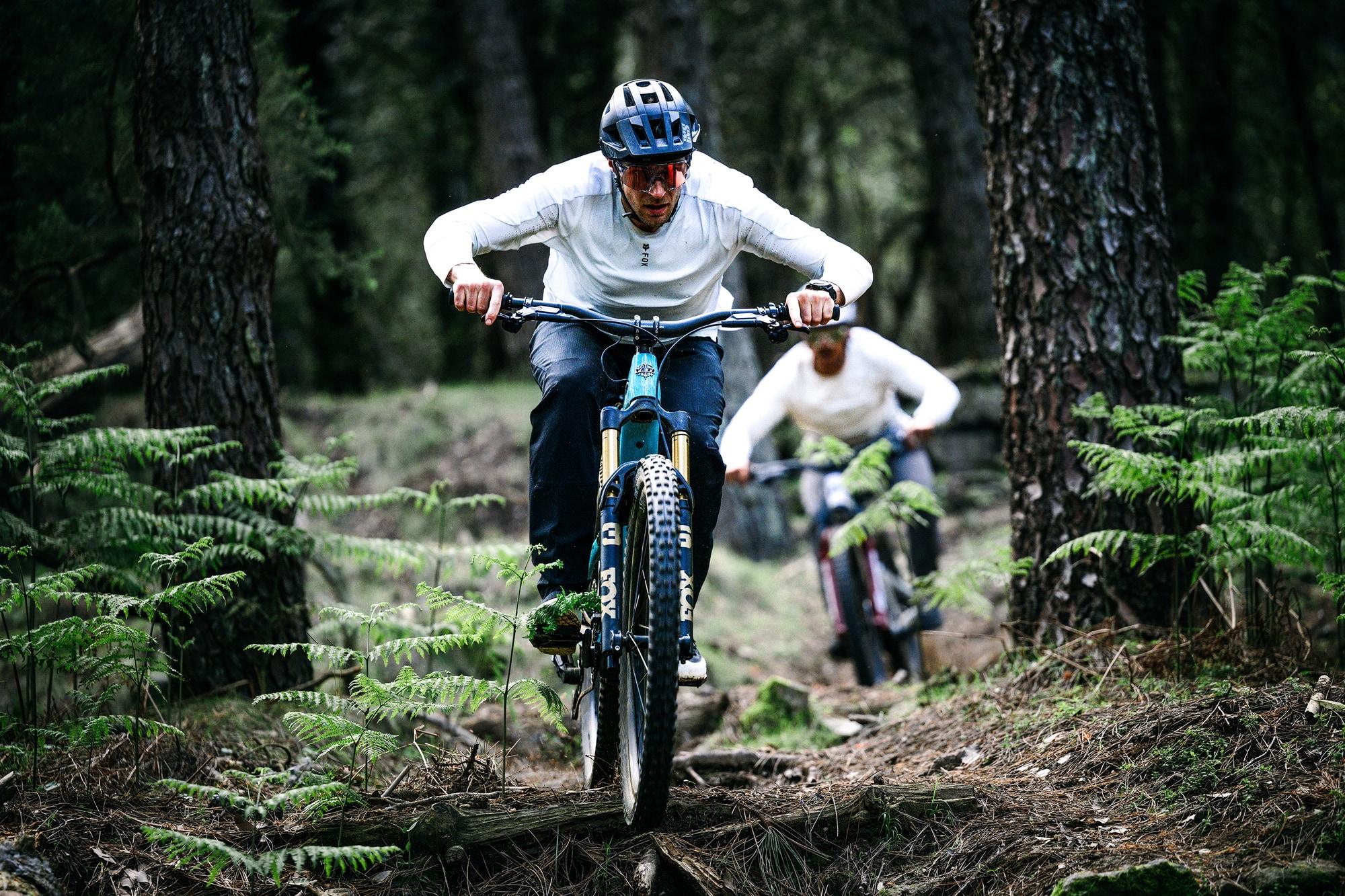Zwei Personen fahren auf Haibike e-MTBs durch den Wald