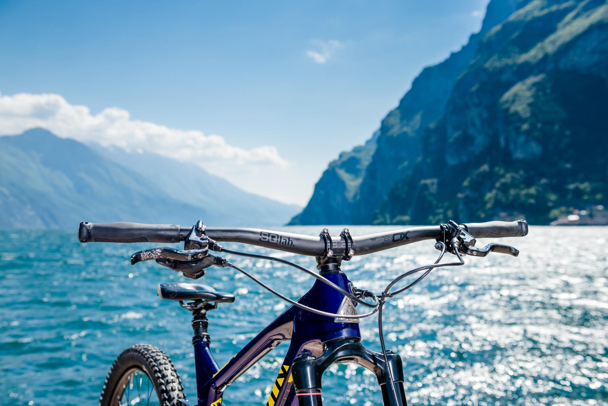 Ein SQlab Fahrrad mit robustem Lenker, ideal für Outdoor-Abenteuer, vor einer atemberaubenden Berg- und Seelandscha