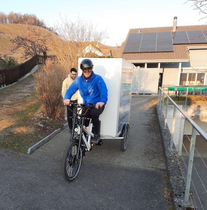 Dreirädrige Radkutsche mit zwei Personen auf ländlicher Straße