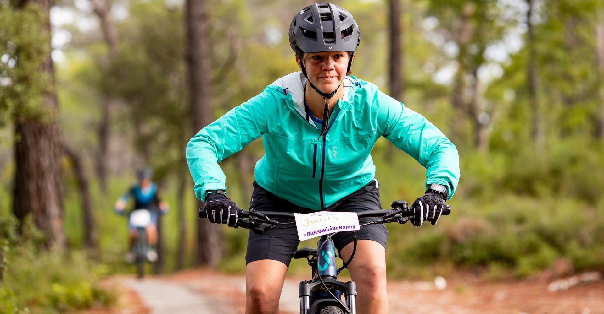 Judith Schäfer von Liv fährt auf einem e-Bike durch den Wald
