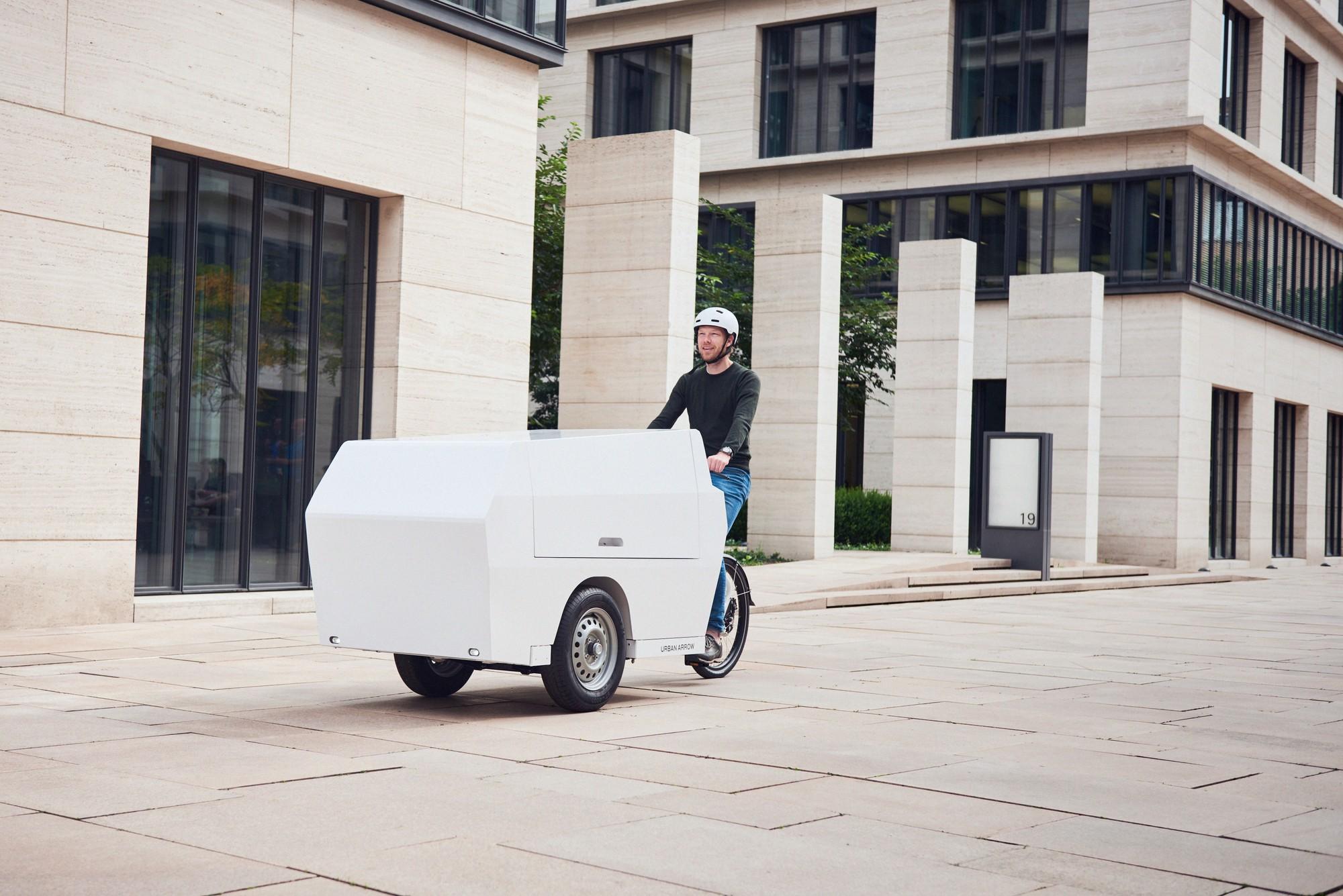 Ein Mann fährt auf dem Urban Arrow Tender durch die Stadt