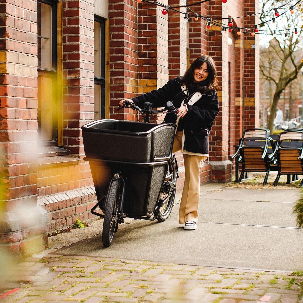 Eine Frau schiebt das Urban Arrow Shorty über die Straße