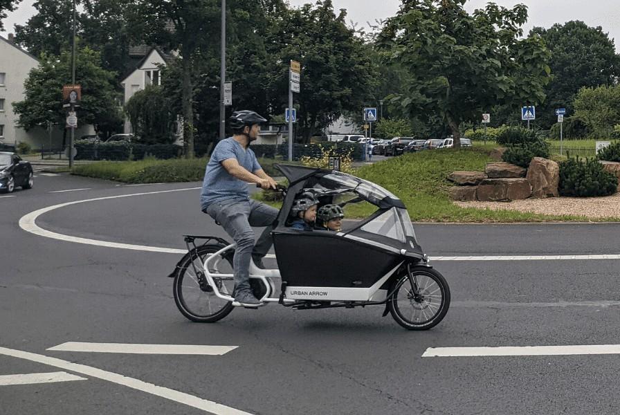 Das Bild zeigt Marcus mit einem Urban Arrow Family mit zwei Kindern