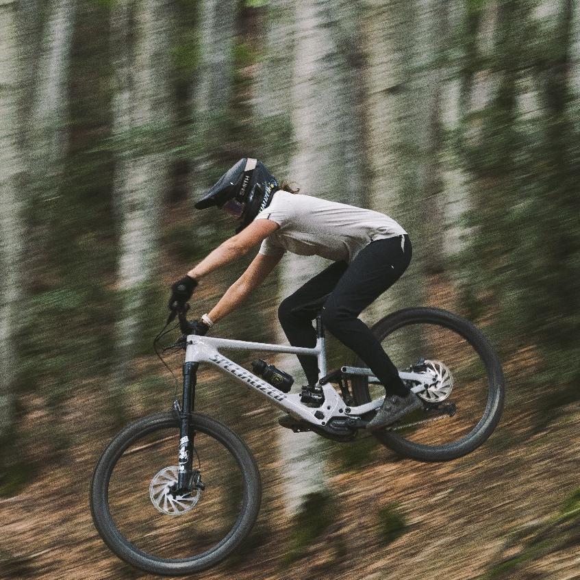 Eine  Person springt mit Specialized Kenevo SL e-MTB im Wald