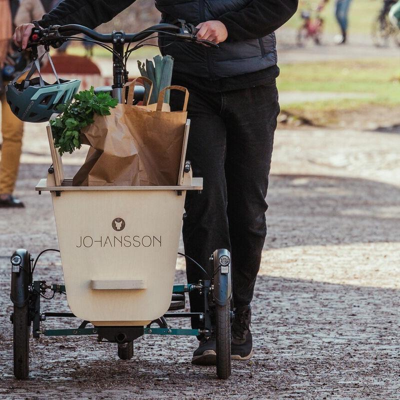 Das Johansson Lastenrad wird vollbeladen durch die Straßen geschoben