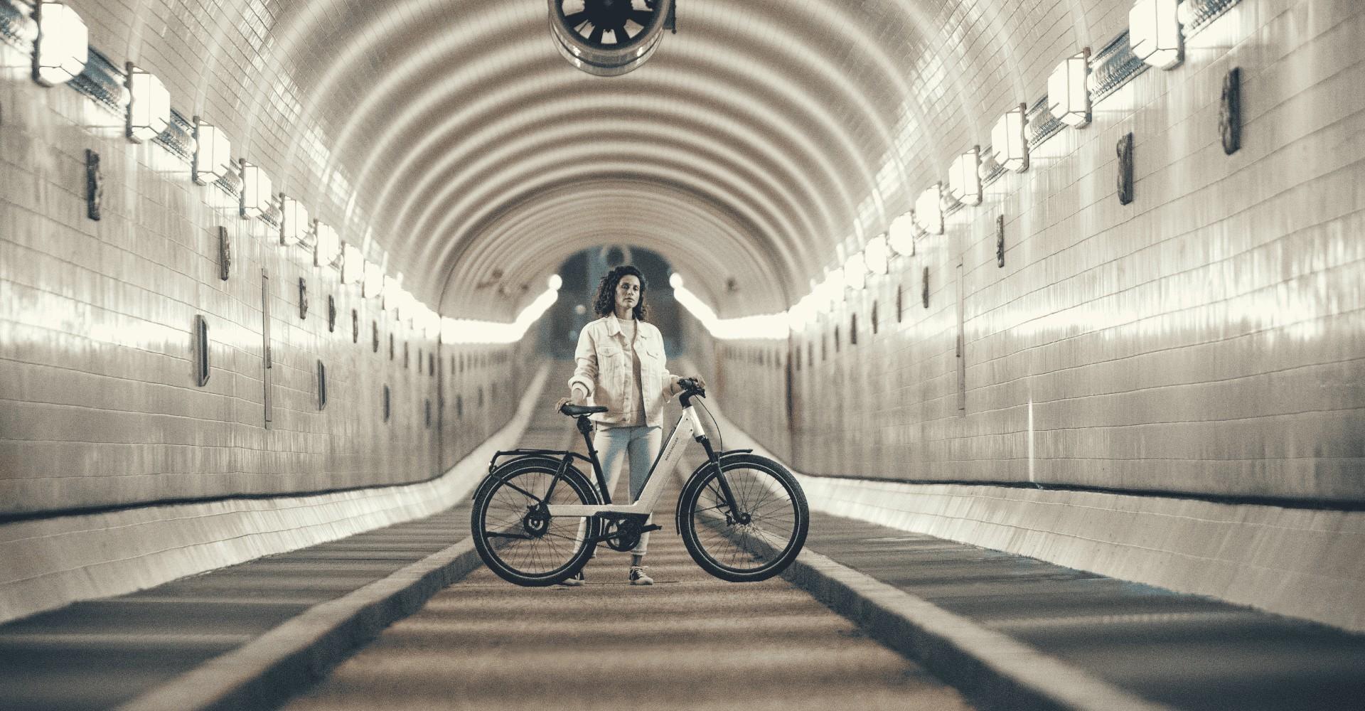 Eine Frau steht mit dem Riese und Müller Nevo e-Bike in einem Tunnel