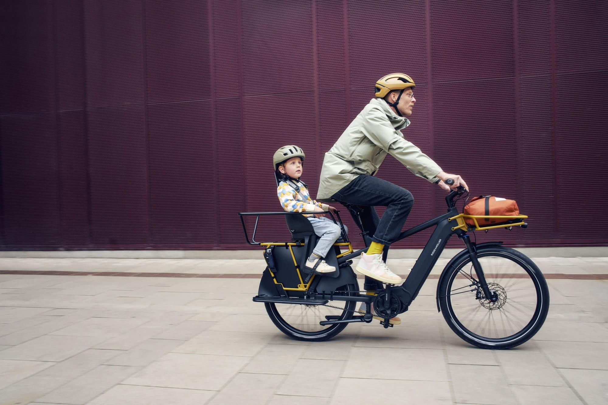 Das Bild zeigt ein E-Bike, Modell Multicharger R&M, dass mit einem speziellen Kindersitz ausgestattet ist.