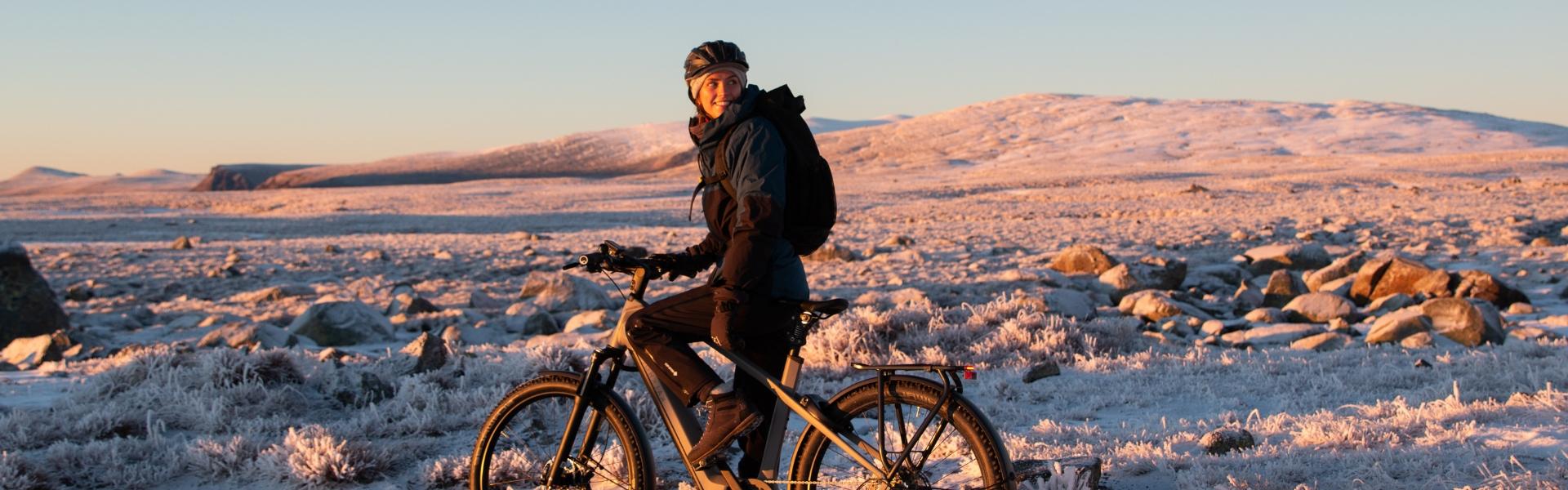 Frau sitzt in winterlicher Umgebungen auf einem e-Bike