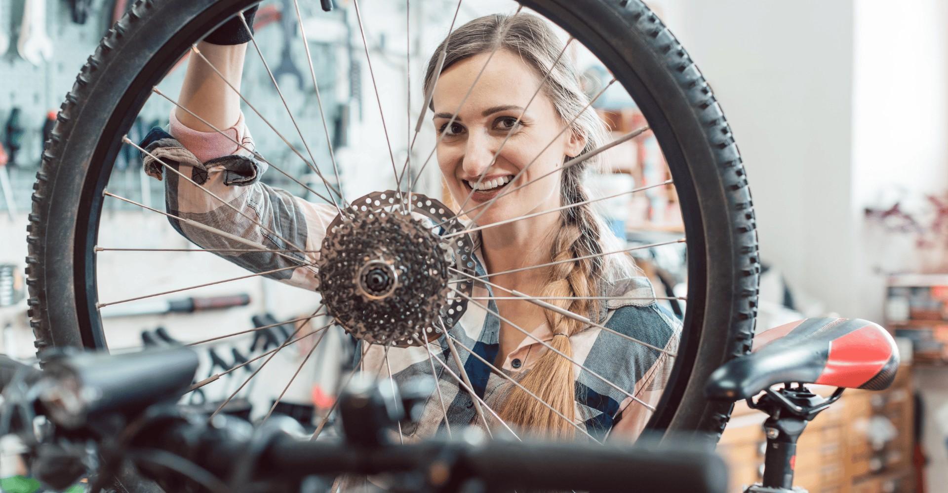 Eine Werkstatt-Mitarbeiterin sitzt hinter einem e-Bike Rad