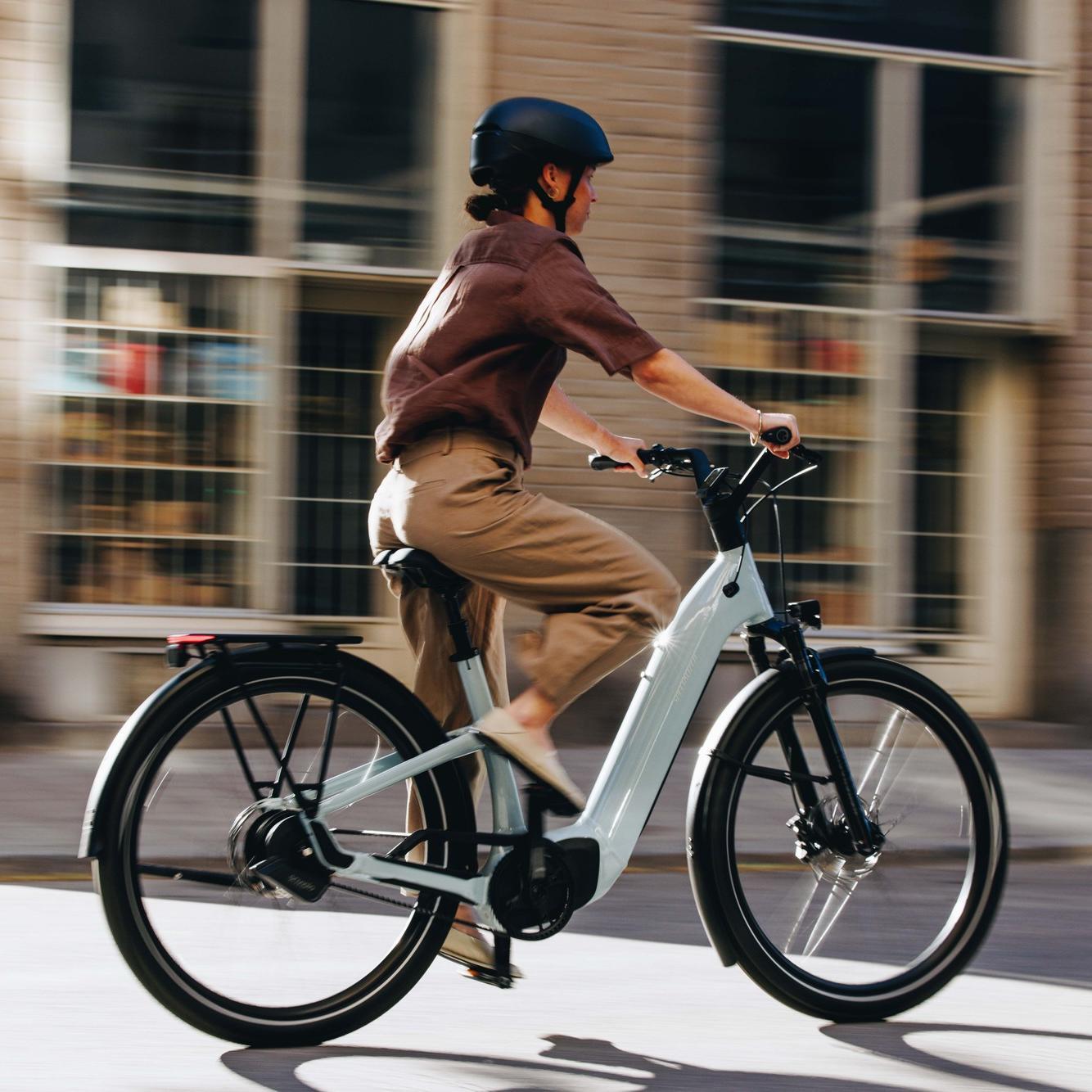 Das Bild zeigt ein Specialized Como E-Bike, das von einer Person in moderner Bekleidung gefahren wird.