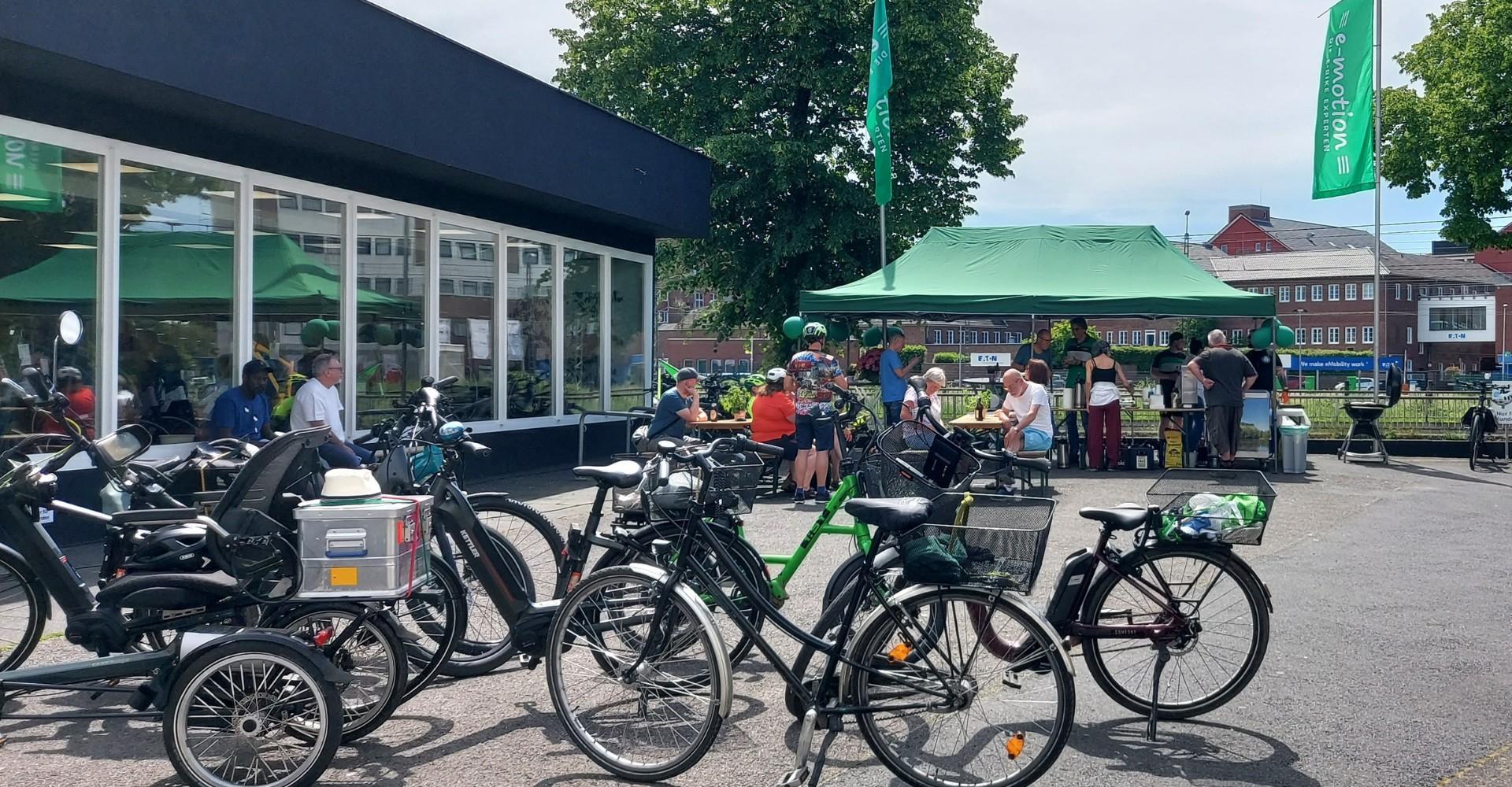 Besucherinnen und Besucher feiern die Eröffnung des neuen e-motion Standorts zwischen ausgestellten e-Bikes.