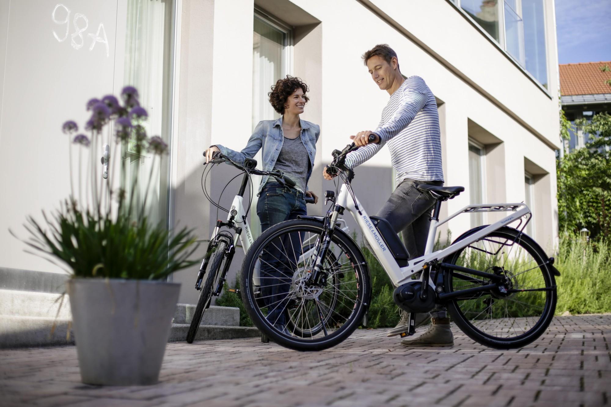 Das Bild zeigt zwei E-Bikes der Marke Riese und Müller, Modell Homage aus dem Jahr 2017, in einem urbanen Umfeld.