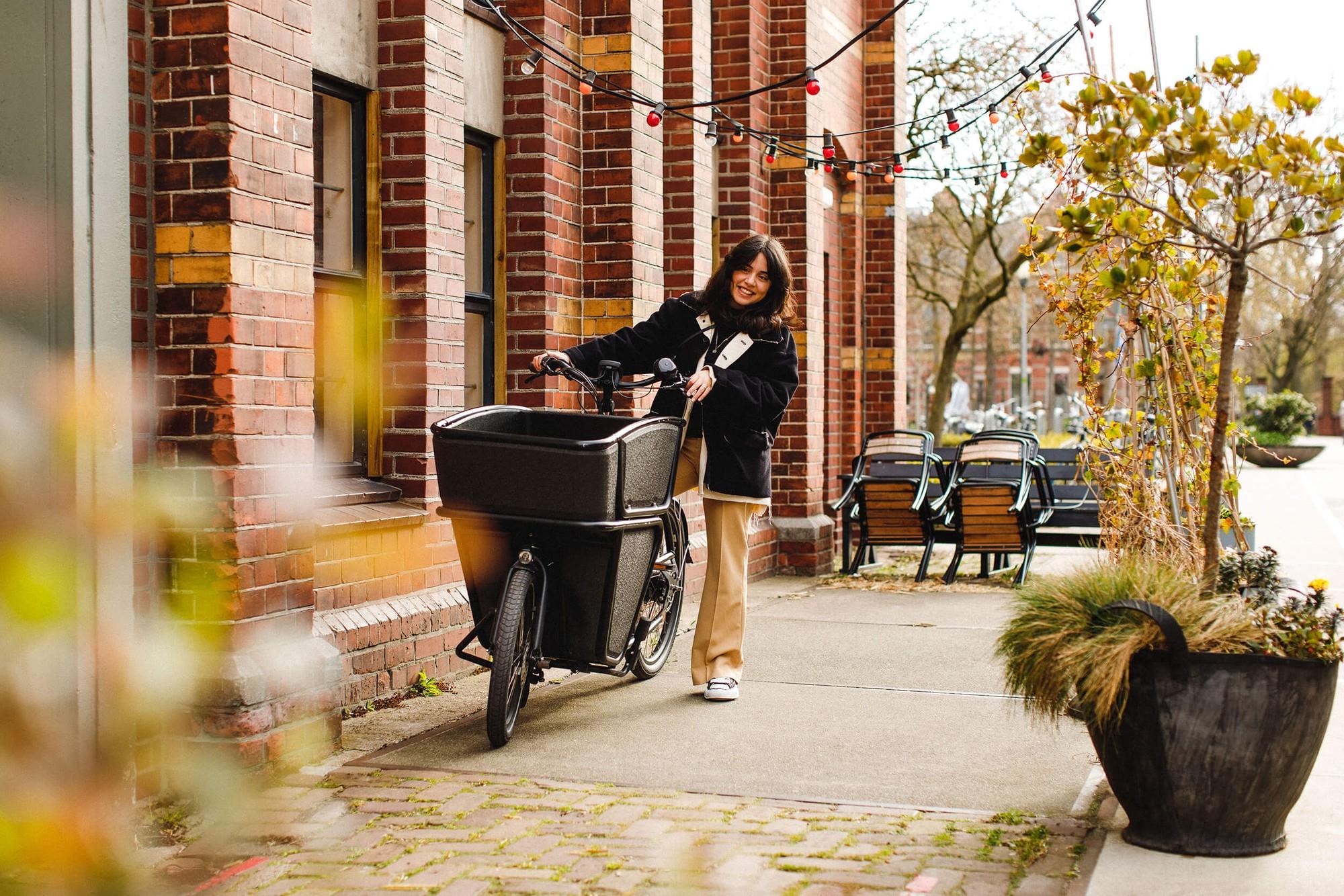 Eine Frau schiebt das Urban Arrow Shorty über die Straße