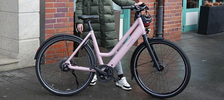 Laura testet das Riese & Müller Culture Mixte Vario und steht mit ihm auf dem Bordstein