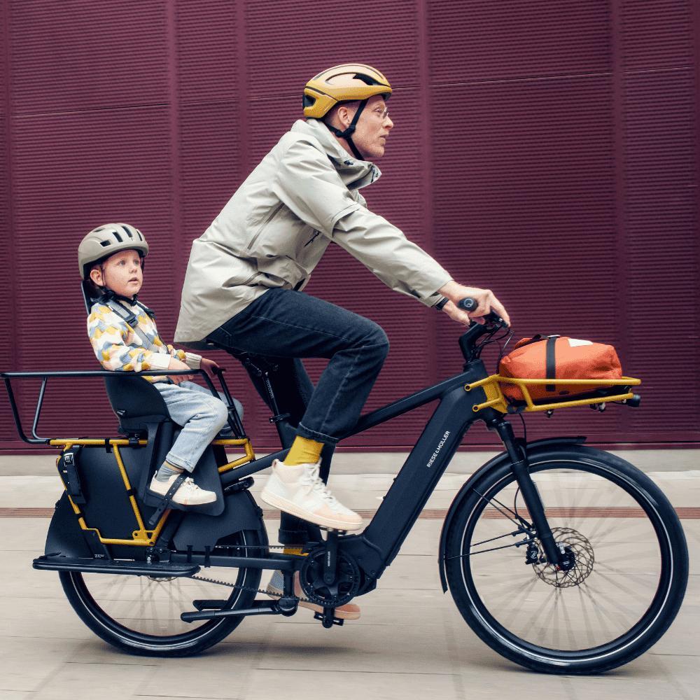 Das Bild zeigt ein E-Bike, Modell Multicharger R&M, dass mit einem speziellen Kindersitz ausgestattet ist.