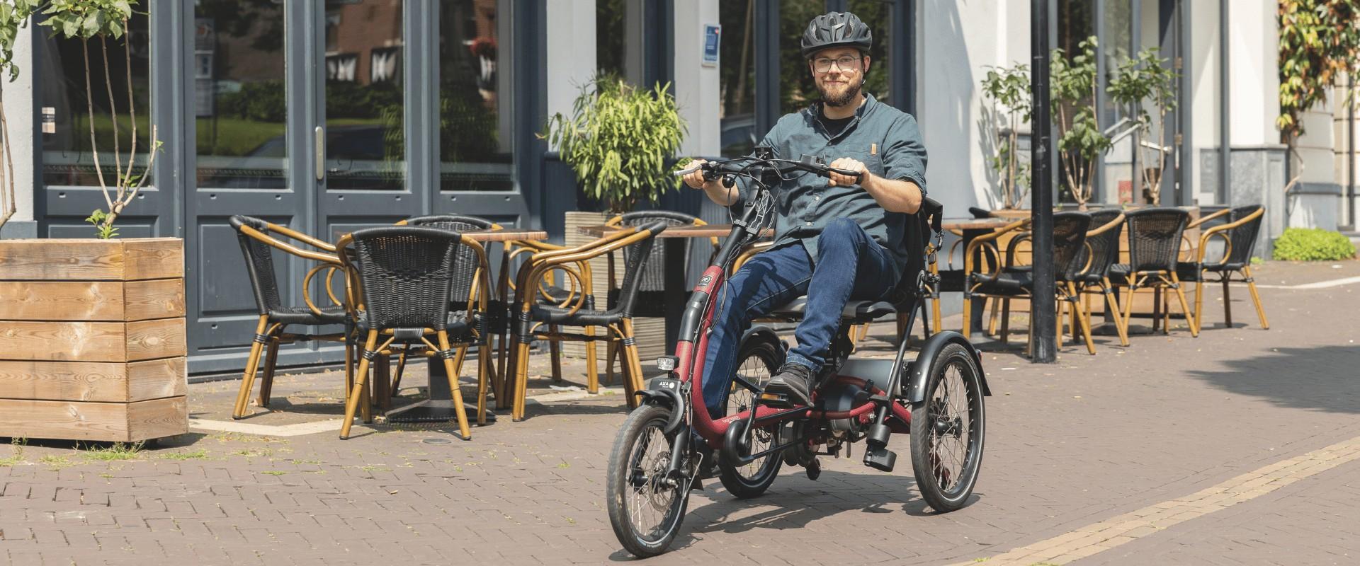 Ein Mann fährt mit dem Easy Rider Compact Dreirad von vanRaam durch die Stadt