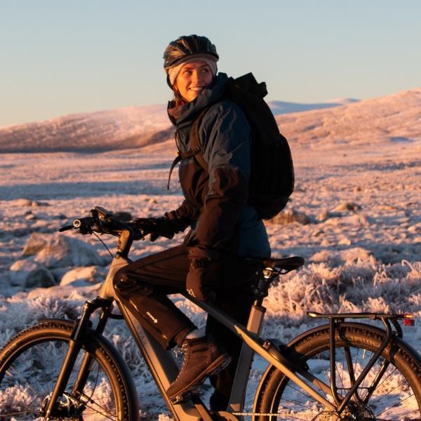 Frau sitzt in winterlicher Umgebungen auf einem e-Bike