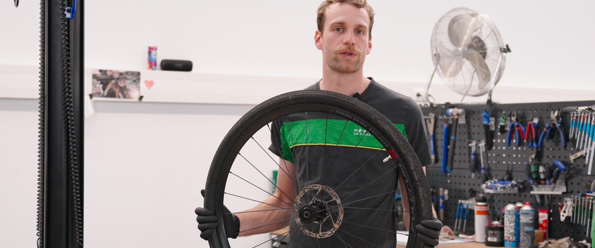 Leon installiert an einem Reifen das Tubeless System