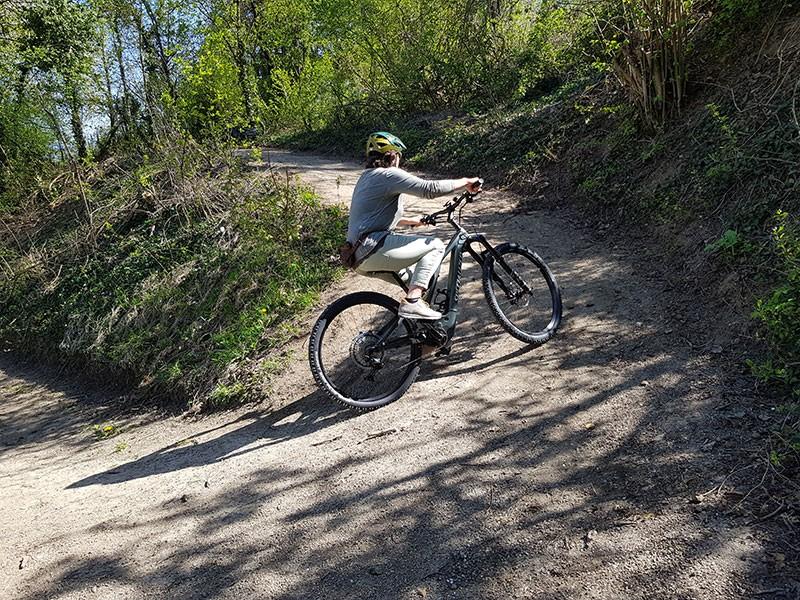Auf dem Bild ist ein Mann zu sehen, der mit seinem e-Bike eine scharfe Kurve im Wald fährt.