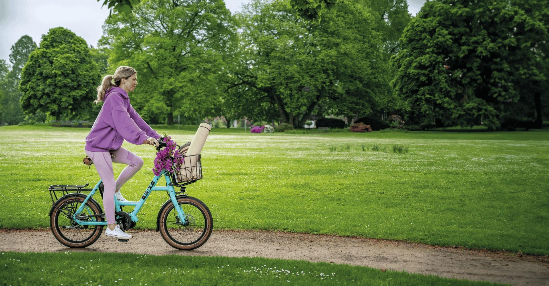 Eine Frau fährt mit dem  i:SY E5 durch den Park