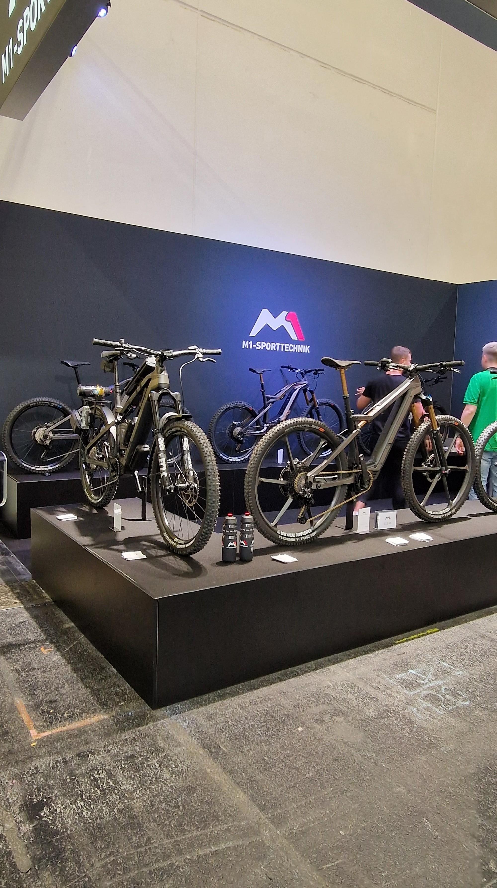 Das Bild zeigt einen Messestand auf der Eurobike 2023 von M1-Sporttechnik auf dem mehrere E-Bikes ausgestellt sind.