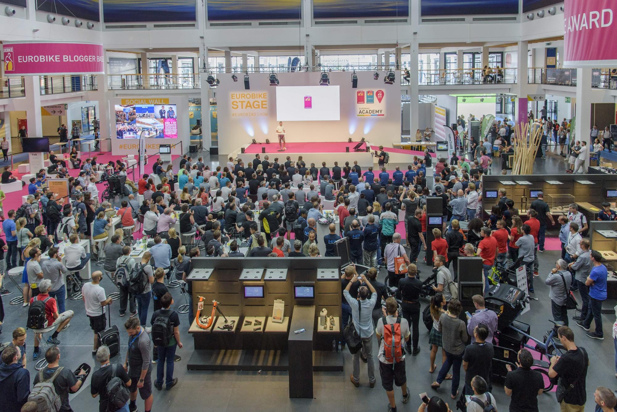 Das Bild zeigt die Eurobike 2018, eine der größten Messen für E-Bikes und Fahrradzubehör. Im Vordergrund ist eine g