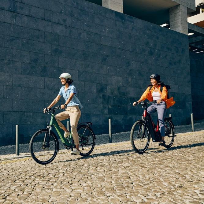 Zwei Personen fahren auf Cannondale Mavaro Neo e-Bikes durch die Stadt