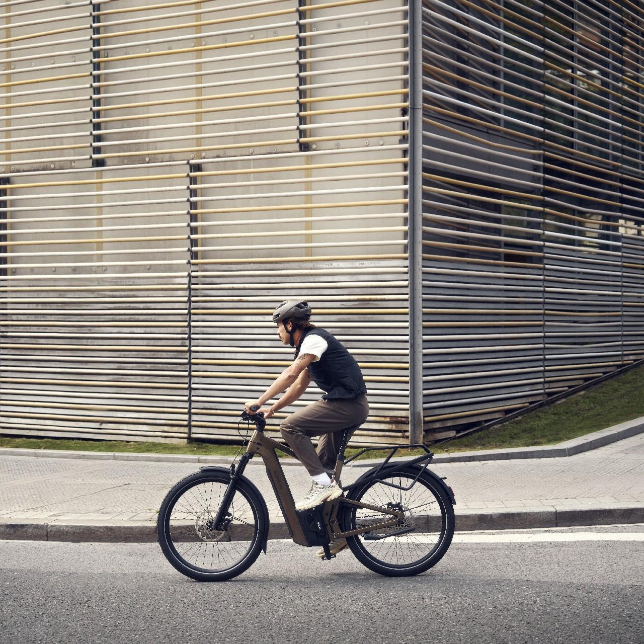 Eine Person auf einem Riese & Müller Delite e-Bike fährt an einer besonderen Wand entlang