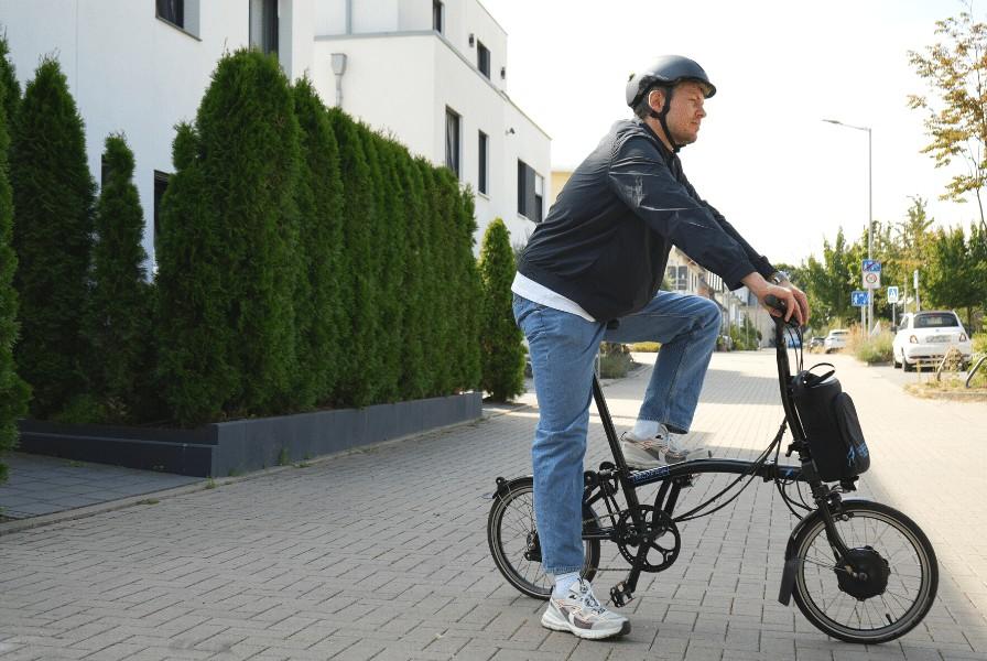Das Bild zeigt Lennart auf einem Brompton Klapp e-Bike C-Line