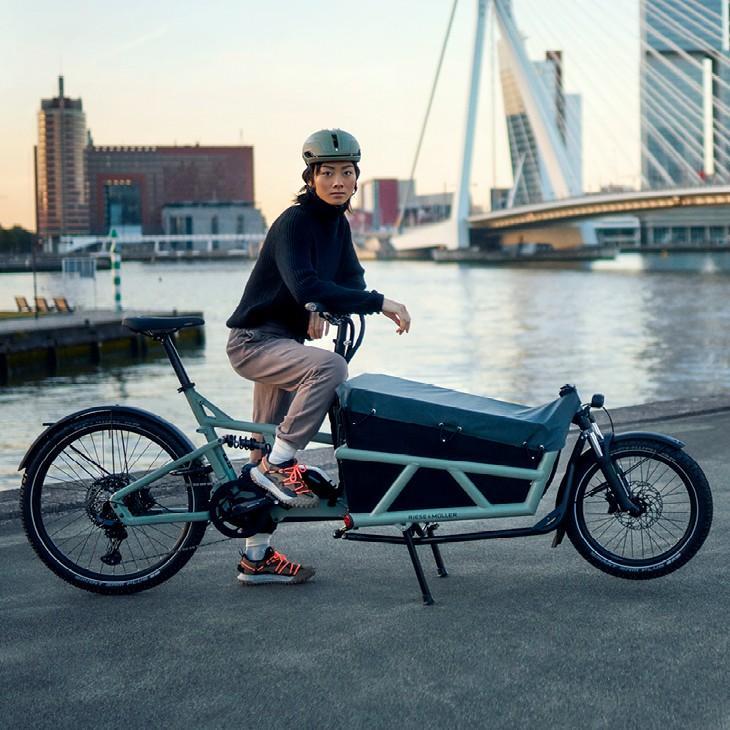 Eine Frau steht mit dem Riese & Müller Load 60 Lastenrad am Wasser