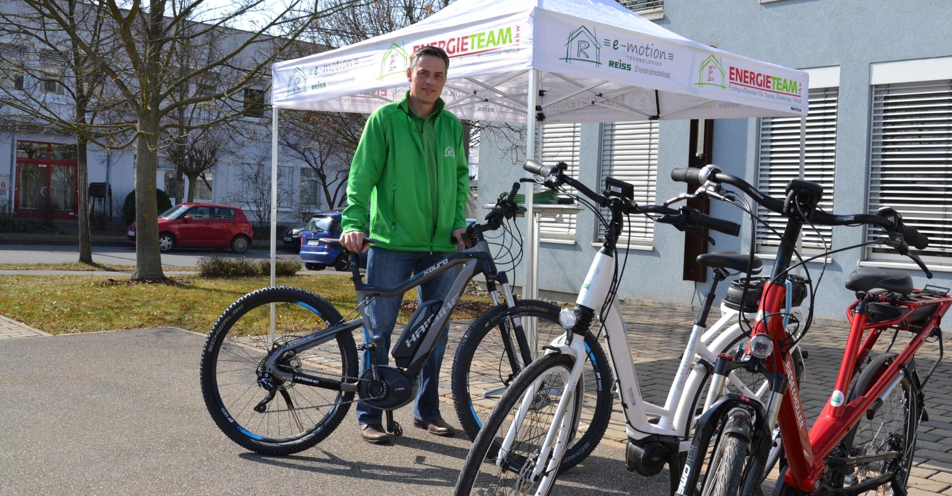 Ein e-motion Mitarbeiter steht vor einem Pavillon bei dem Elektro-Fahrrad-Stadtfest 2015 in Würzburg.