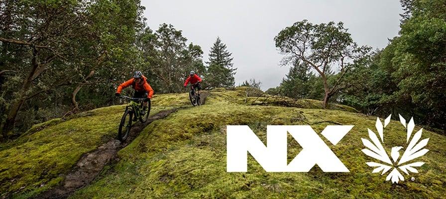 Mountainbiker fahren auf einem Waldweg mit NX-Logo