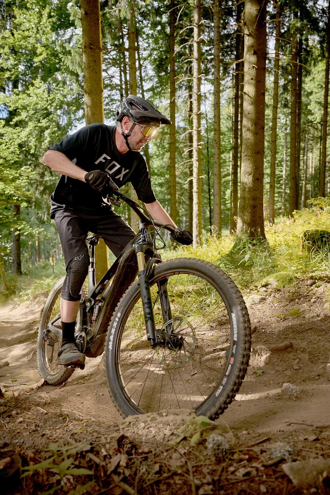Ein Mann fährt mit einem Mountainbike von Giant durch den Wald