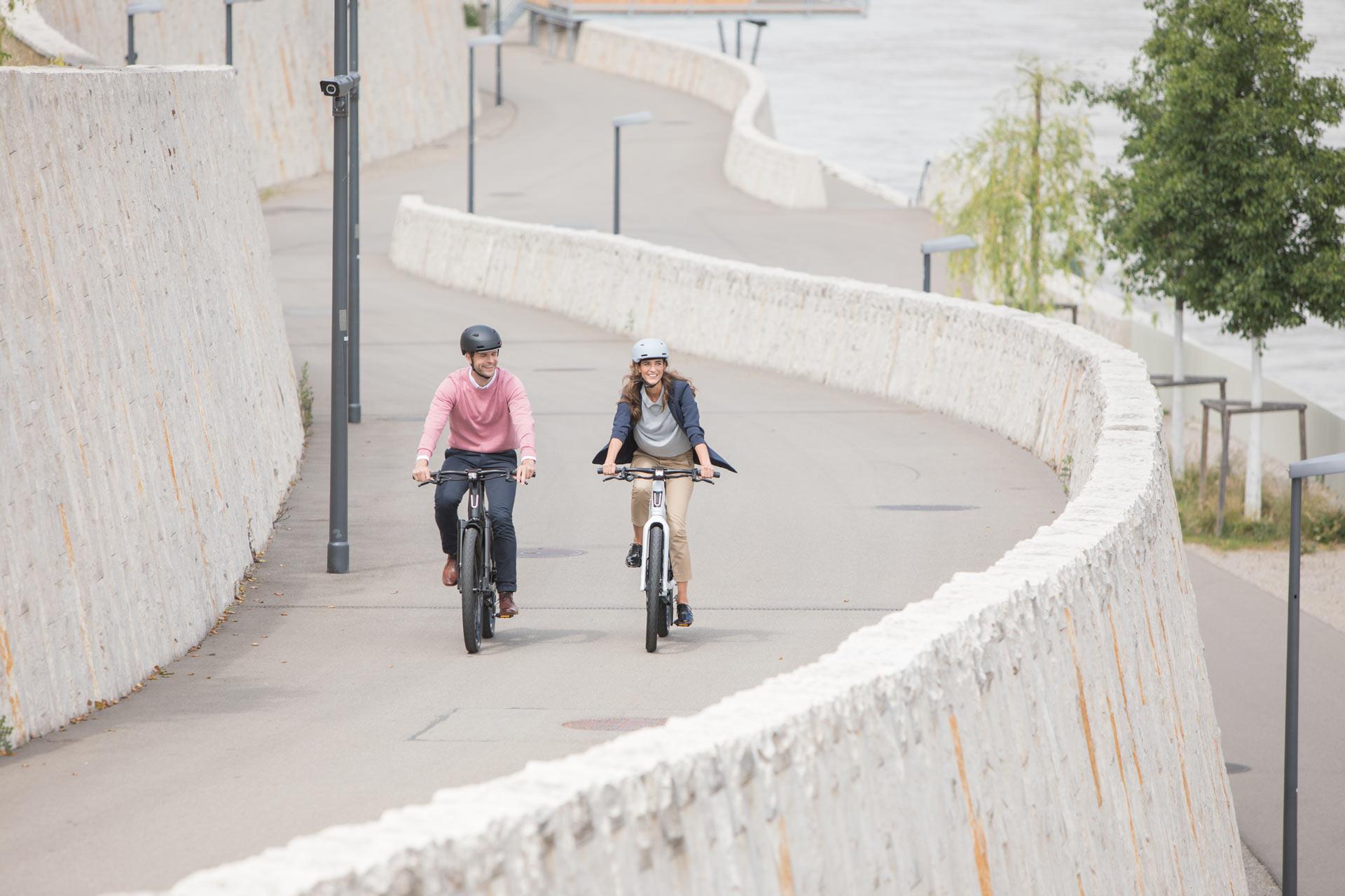 Zwei Personen fahren auf Stromer ST3 E-Bikes eine kurvenreiche Straße entlang. Ideal für moderne Mobilität und stil