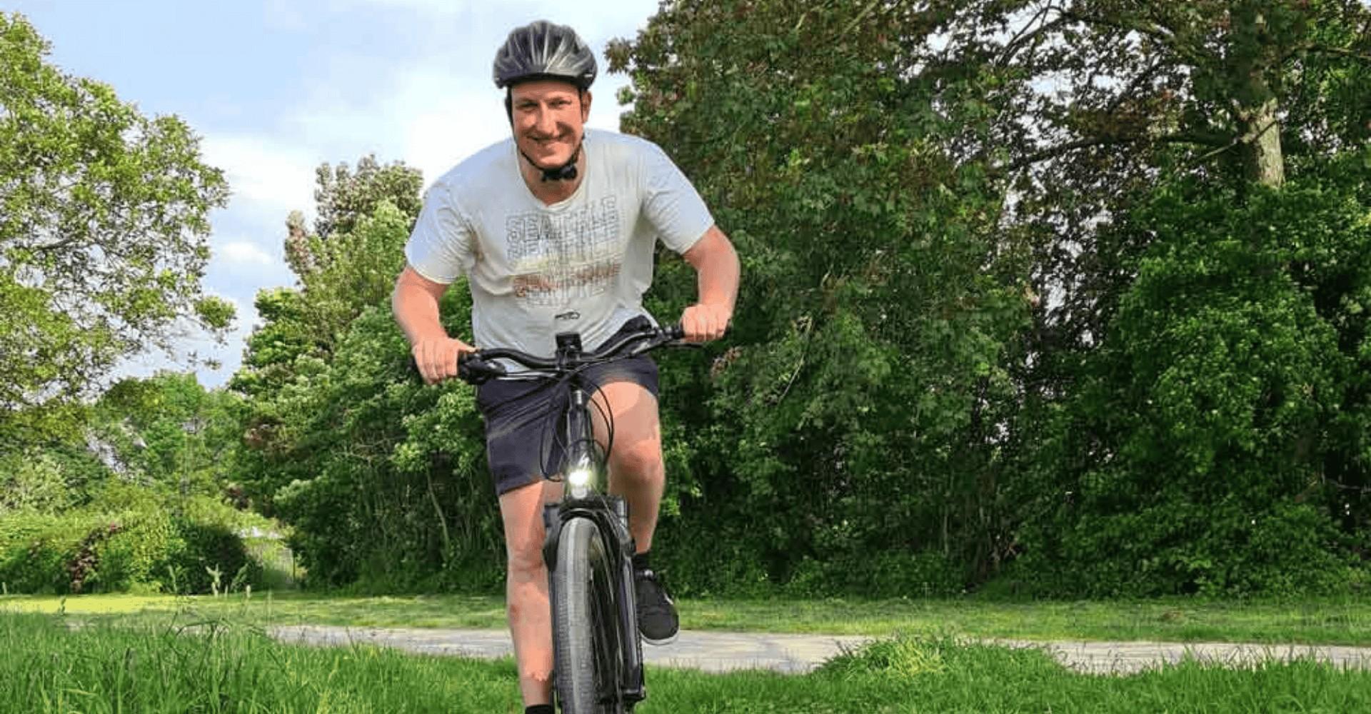 Ein Mann fährt durch das Grüne mit dem Specialized Turbo Vado 5.0