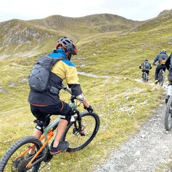 Mountainbiker auf schmalem Pfad in alpiner Landschaft