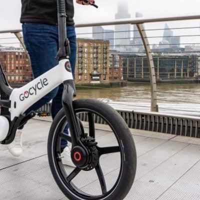 Gocycle E-Bike auf Brücke mit Stadt im Hintergrund