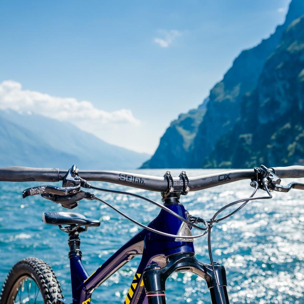 Ein SQlab Fahrrad mit robustem Lenker, ideal für Outdoor-Abenteuer, vor einer atemberaubenden Berg- und Seelandscha