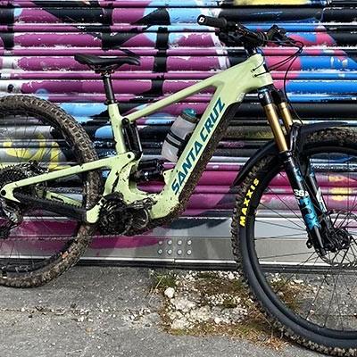 Hochwertiges Santa Cruz Mountainbike vor bunter Graffiti-Wand. Perfekt für Abenteuer im Gelände.