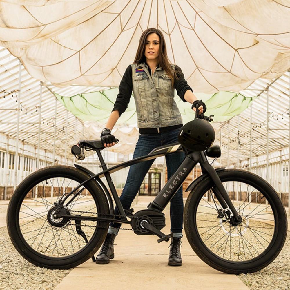 Frau posiert hinter einem Electra Café Moto Go!