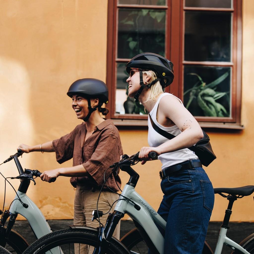 Zwei Personen genießen eine Fahrradtour auf Specialized Como E-Bikes, ideal für urbane Ausflüge mit Stil und Komfor
