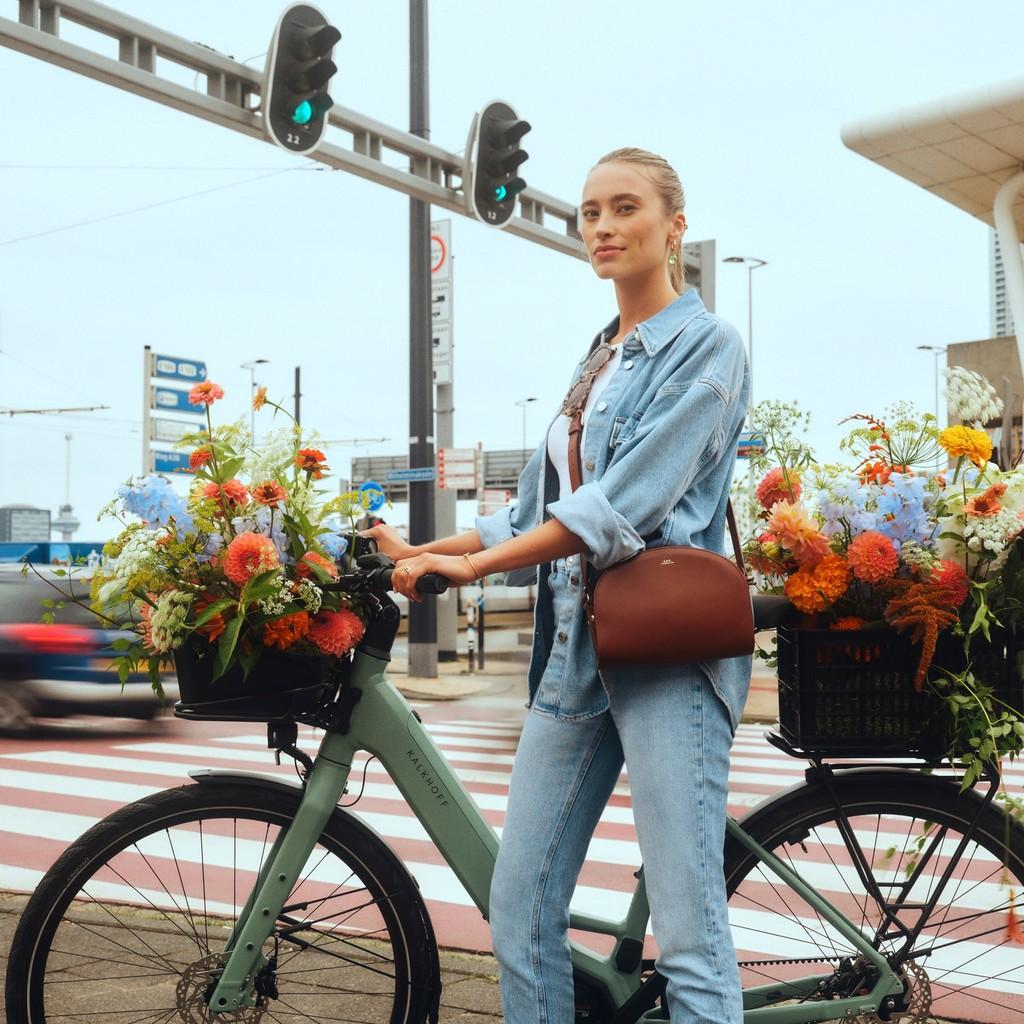 Erleben Sie den Komfort eines Kalkhoff E-Bikes, stilvoll präsentiert mit einem Korb voller bunter Blumen. Perfekt f