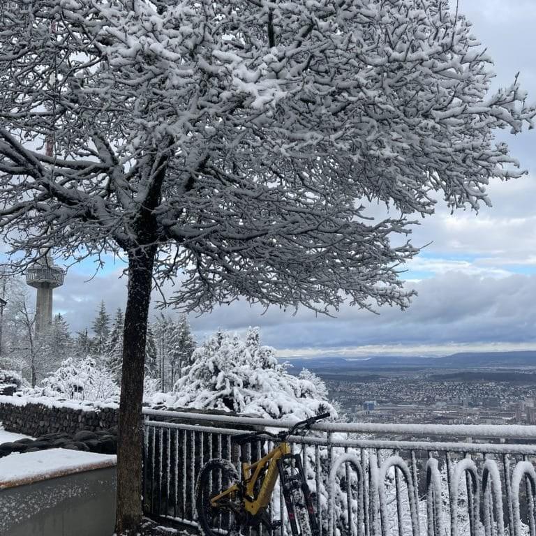 Verschneites E-Bike vor Aussichtspunkt mit Winterlandschaft
