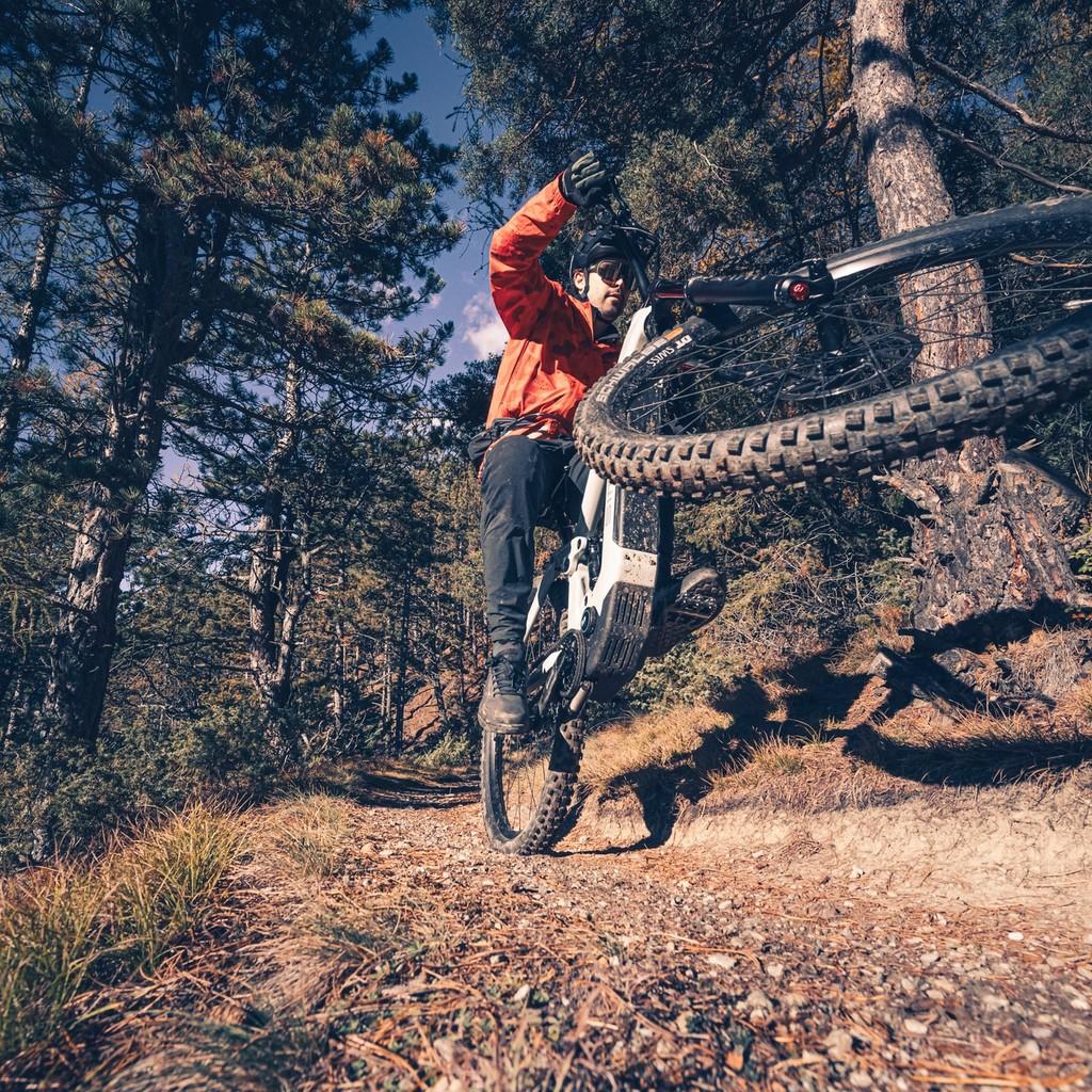 Mann fährt mit seinem e-Mountanbike einen steilen Abhang runter.