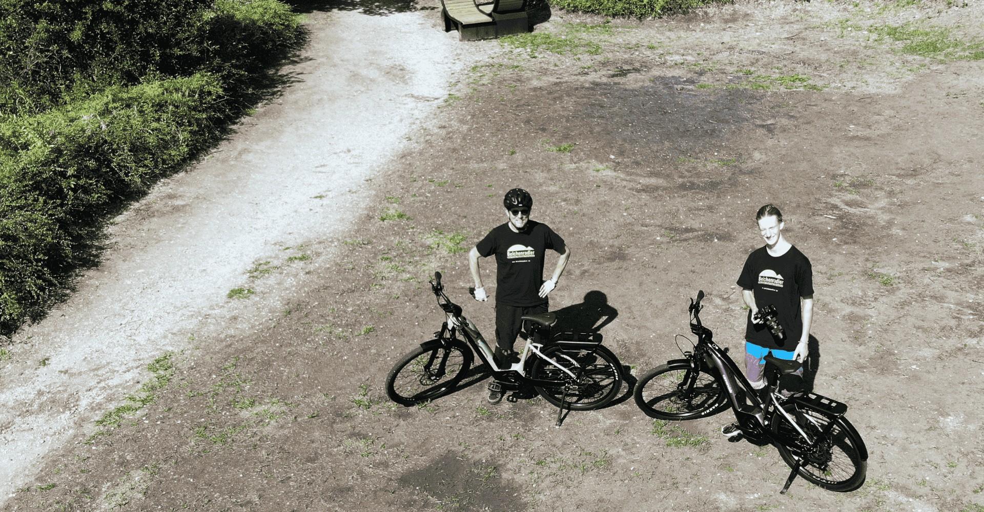 Zwei Personen stehen mit ihren e-Bikes in der Natur