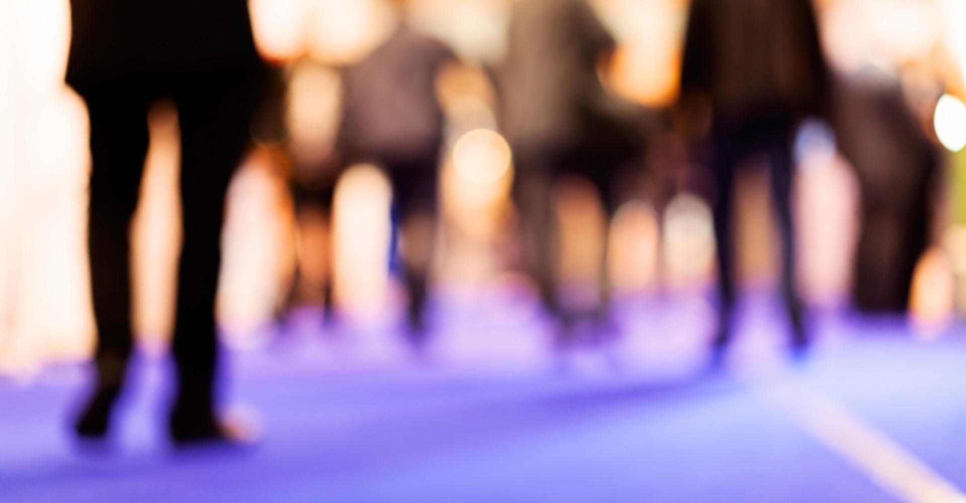 Verschiedene Personen, die über einen Teppich gehen