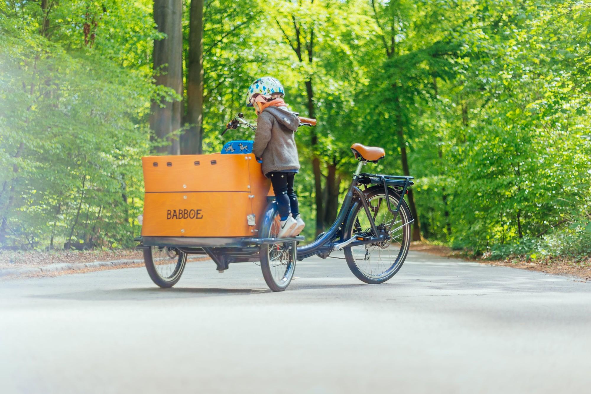 Ein kleiner junge wird auf einem Lasten e-Bike nach dem e-motion e-Bike Days nach Hause gefahren.